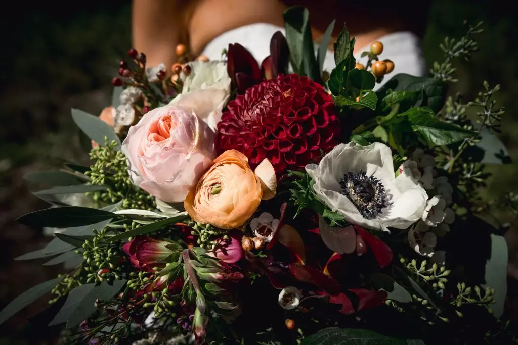 burgundy, peach and white flowers in wedding bouquet