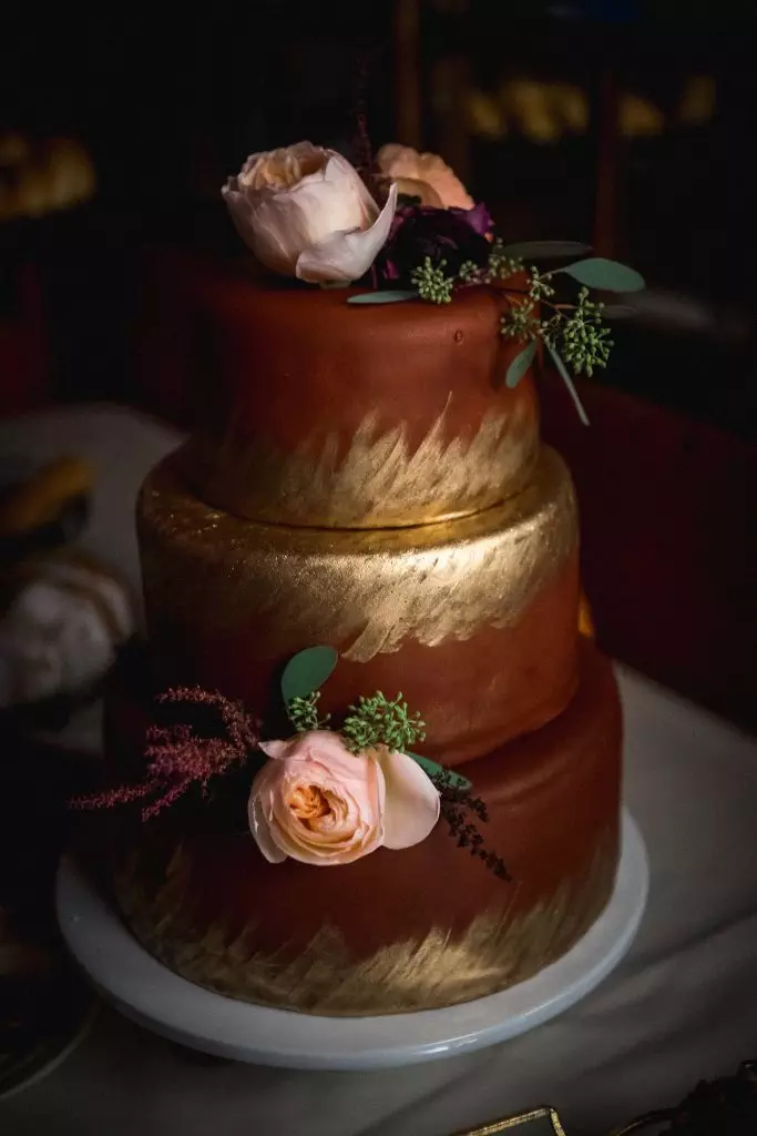 maroon cake with gold hand panting